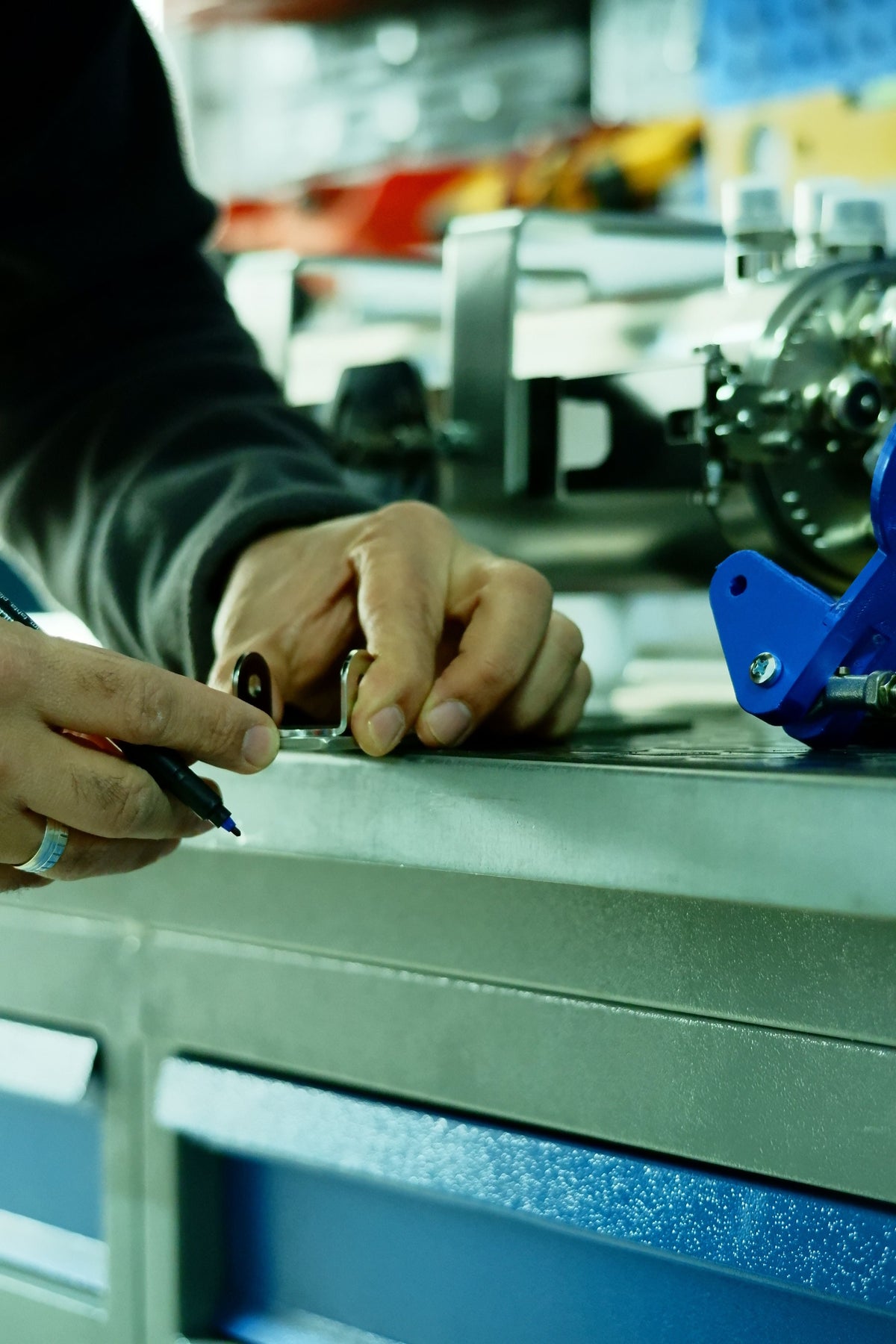 Mains d'un opérateur sur une machine de l'atelier de fabrication